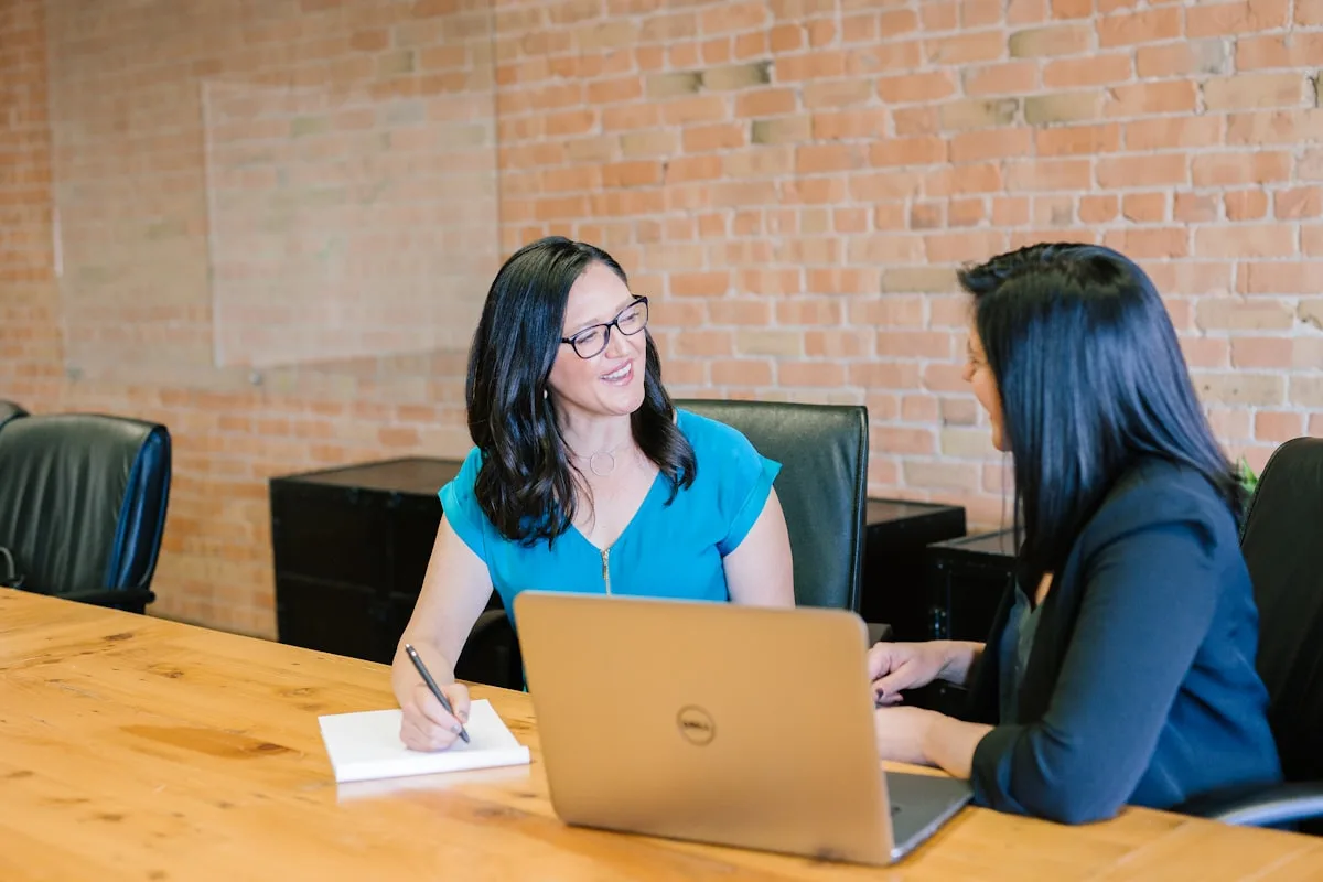 Professional mentor training a young colleague in a workplace setting