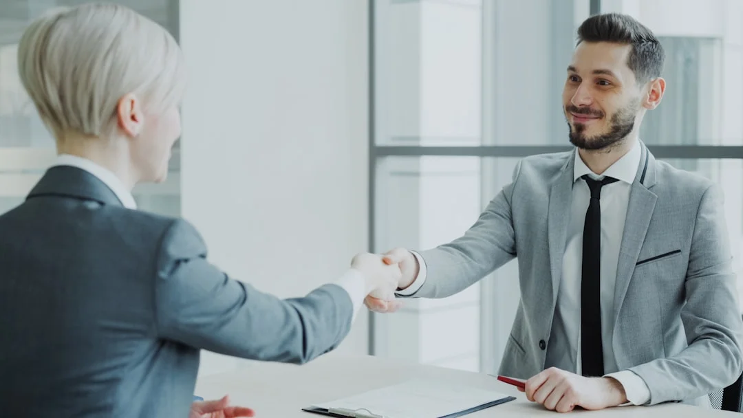 Professional handshake representing a brokered business transaction