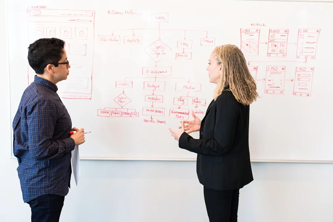 Entrepreneur reviewing business strategy at whiteboard in professional meeting