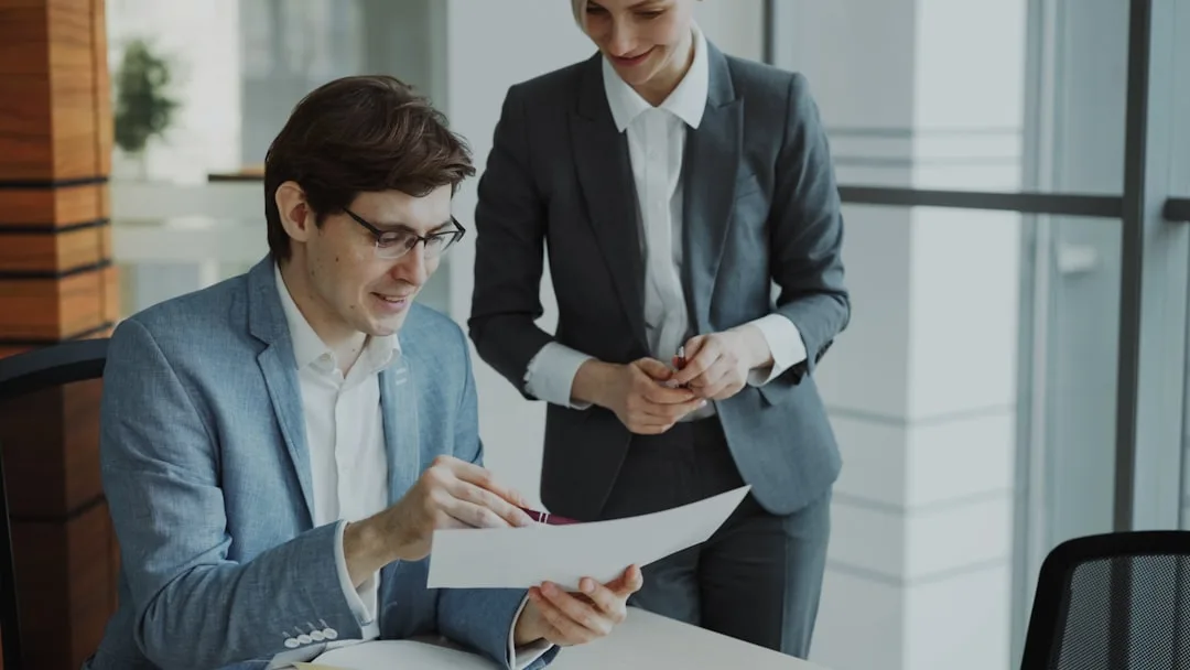 Two professionals reviewing contract documents at a conference table