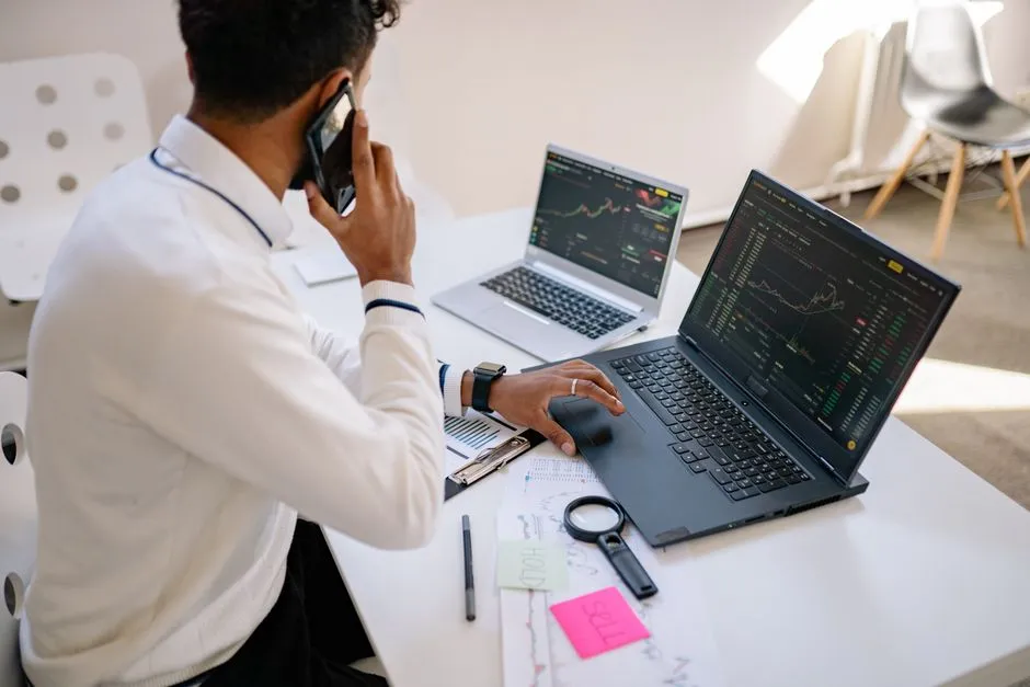Professional analyzing demographic and economic data on a laptop with charts and spreadsheets