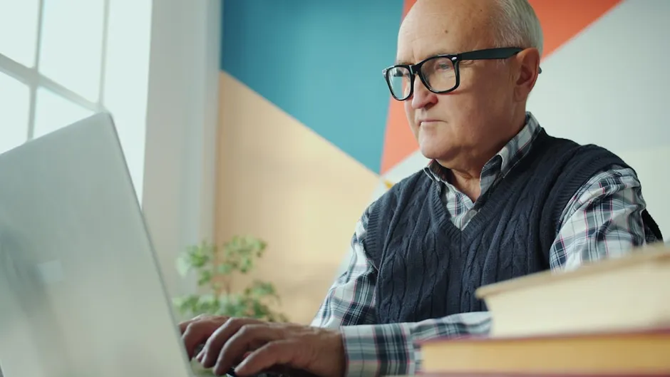 Senior business owner looking at computer in a traditional office environment