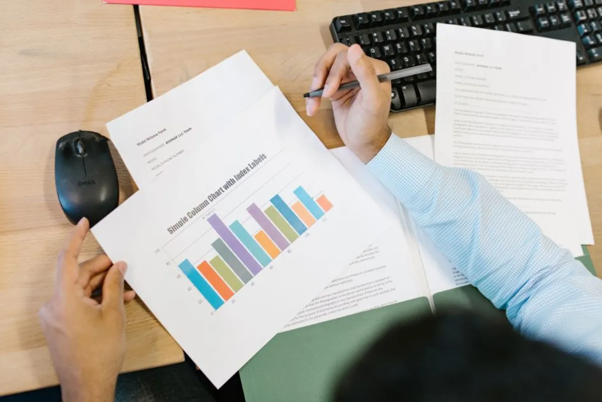 Business analyst reviewing spreadsheet data on laptop with charts