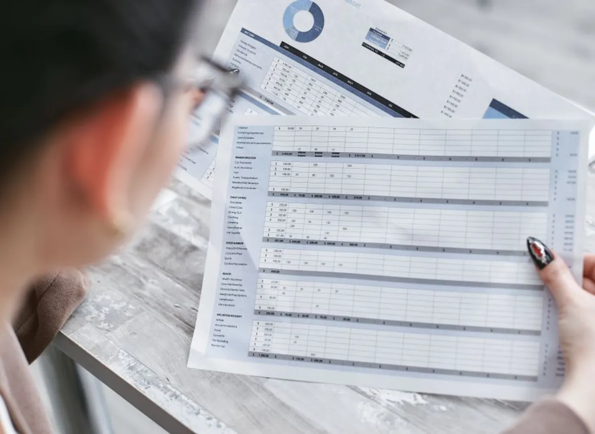 Professional reviewing financial documents and spreadsheets at a desk