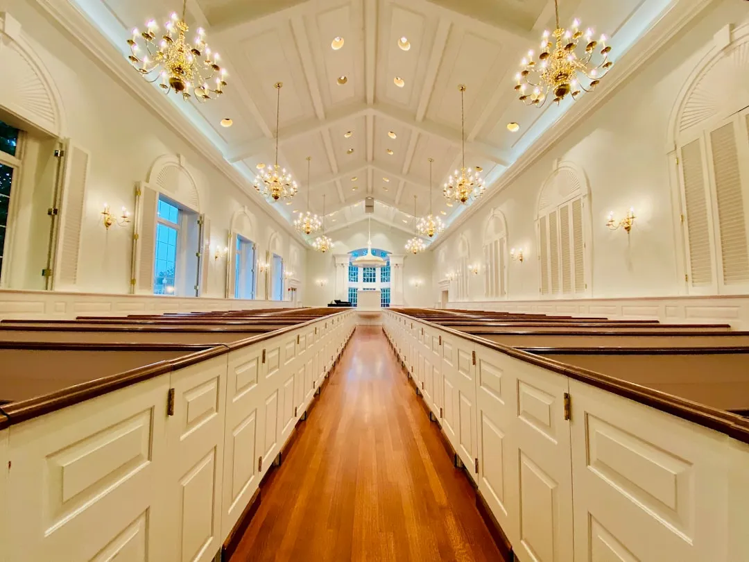 Warm interior of a traditional chapel with wooden pews and soft lighting