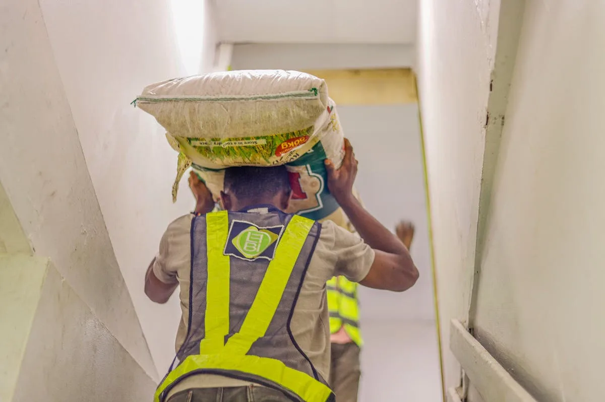 Worker carrying heavy load up stairs in a physically demanding work environment